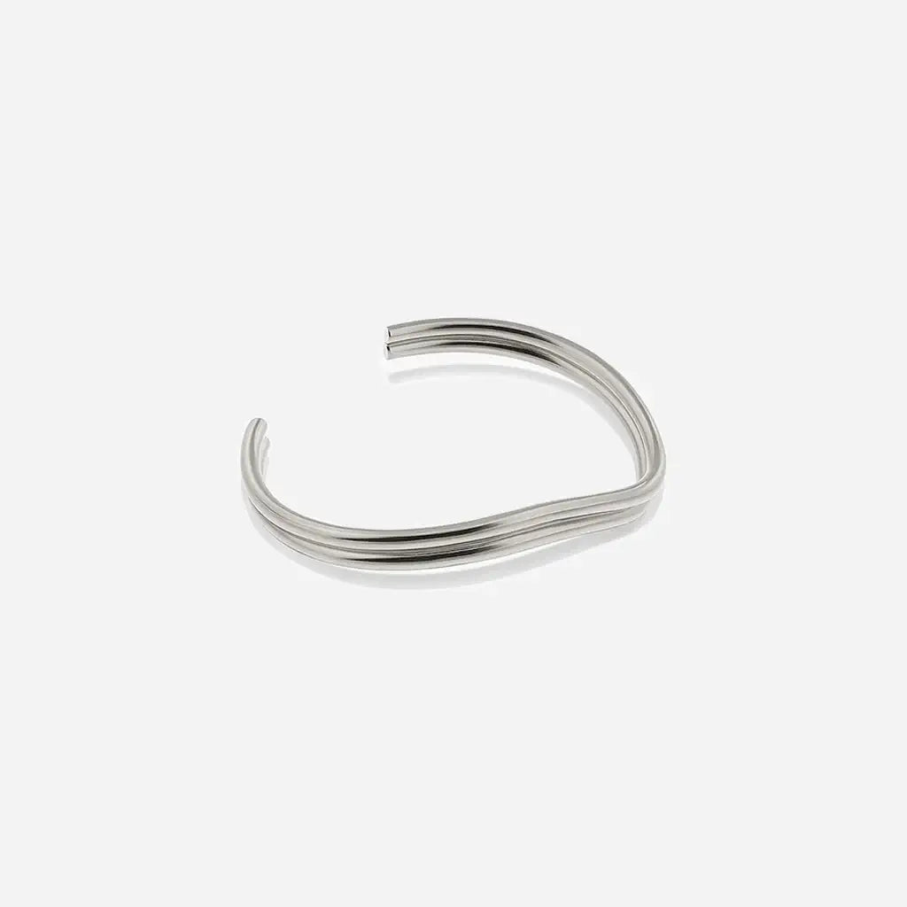 Jonc fin Anomalie, bracelet ouvert unisexe en métal satiné argenté, à la fois ondulé, structuré et graphique.