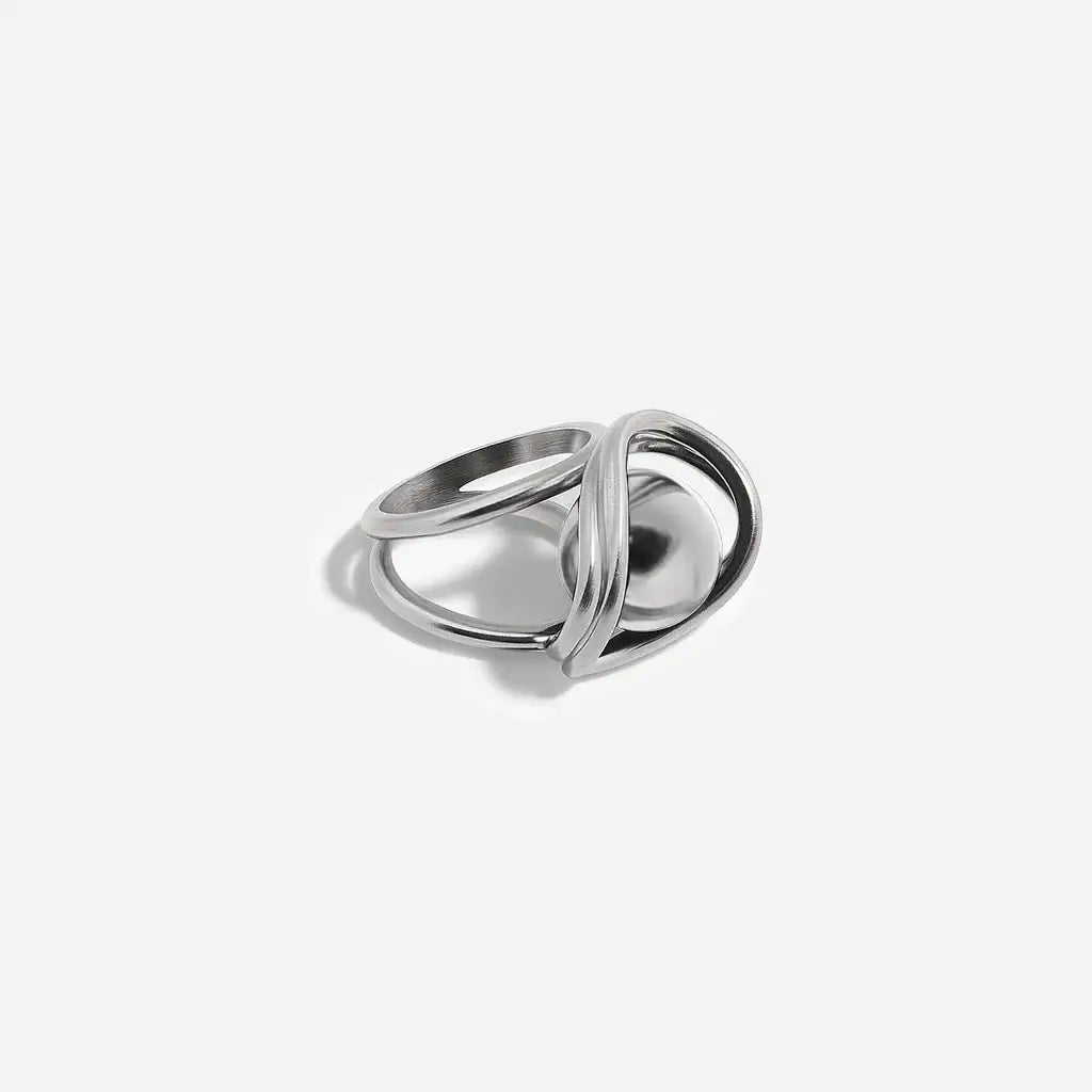 Une bague perle moderne Anomalie au design graphique en métal satin argenté, perle en métal argenté, à structure double.