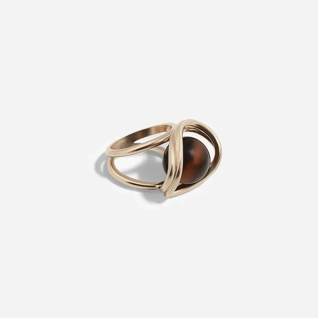 Une bague perle moderne Anomalie en métal satin doré et perle en œil de tigre avec structure double.