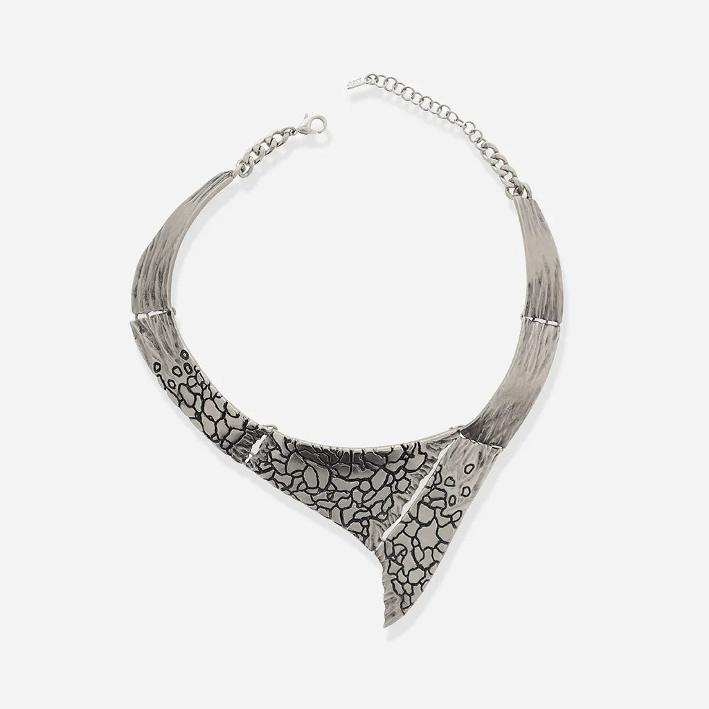 Un collier torque Turbulence en vieil argenté à structure rigide en métal avec motifs texturés vieillies.