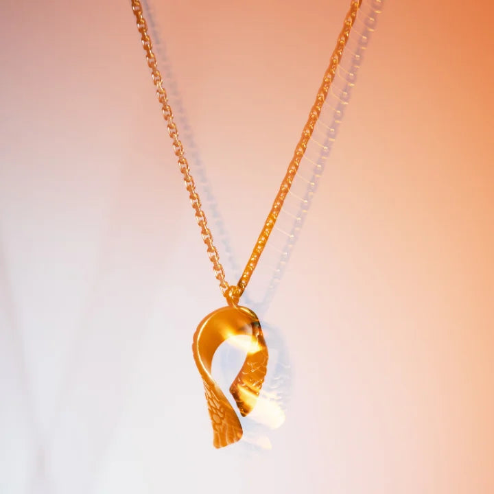 Collier pendentif Trouble en vieux doré, chaîne fine en métal et pendentif élégant en aile articulée.