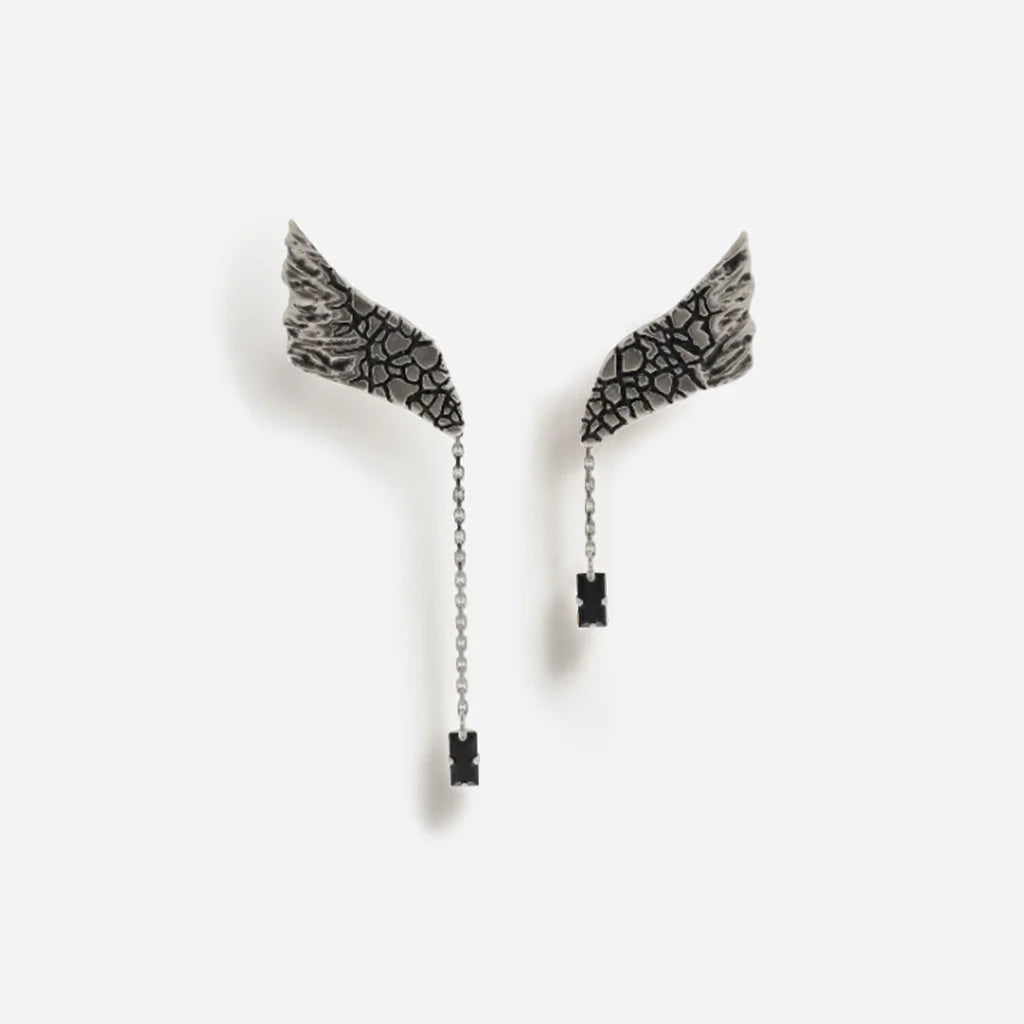 Boucles d’oreilles ailes Trouble en vieil argenté, à forme asymétrique avec finition gravée et texture raffinée.