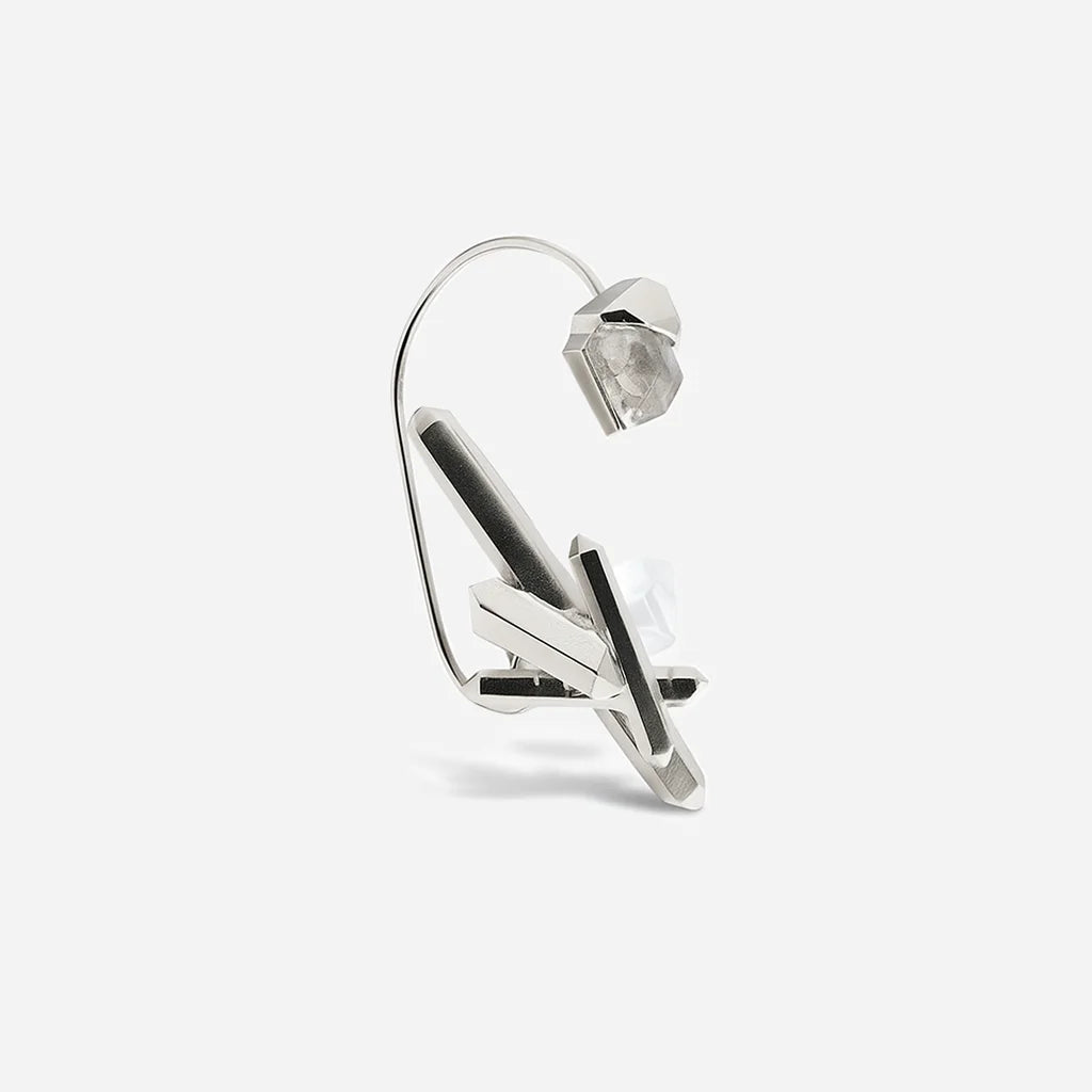 Bijou d'oreille créateur Turbulence en métal argenté avec deux volumes cristallins reliés par une tige.