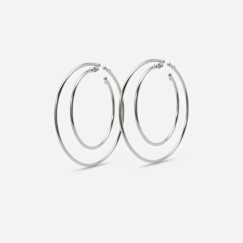 Set de quatre créoles boucles d'oreilles Eden en métal argenté : une se glisse dans le creux sans piercing, l’autre se pose sur le lobe.