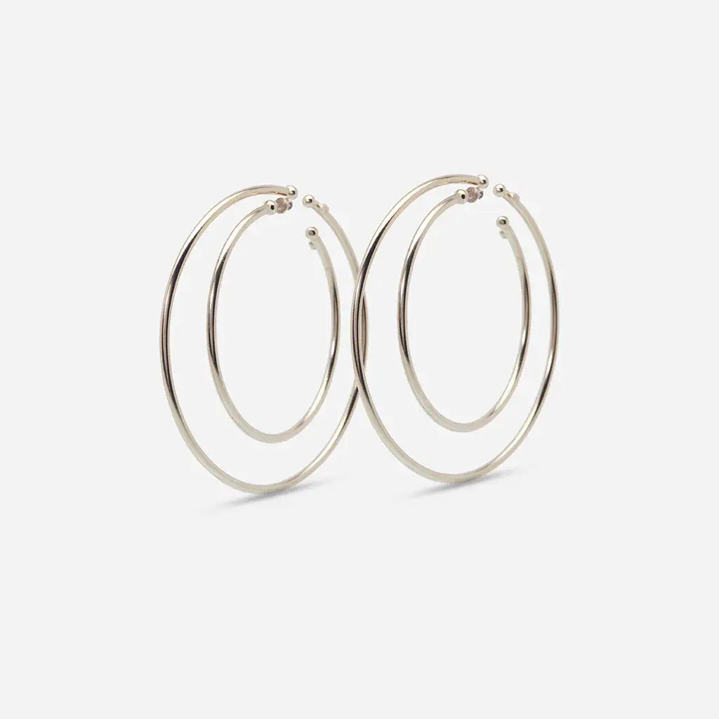 Set de quatre créoles boucles d'oreilles Eden en métal doré : une se glisse dans le creux sans piercing, l’autre se pose sur le lobe.
