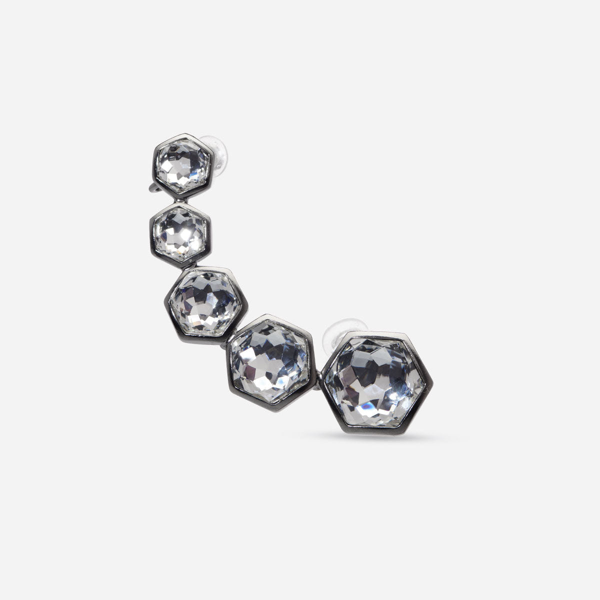 Boucle d’oreille Alma hexagonale en métal satiné ruthénium / cristal, avec clip sur le haut de l’oreille et tige sur le lobe.