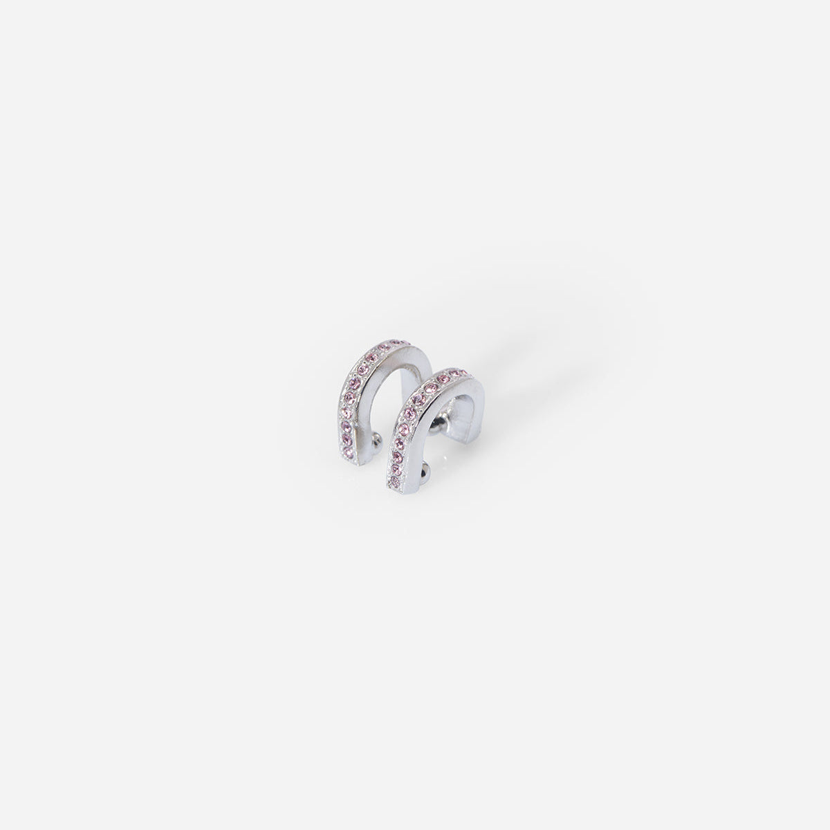 Bijou d’oreille Eden en métal satiné argenté, double barrette arrondie ornée de strass roses, au style graphique.