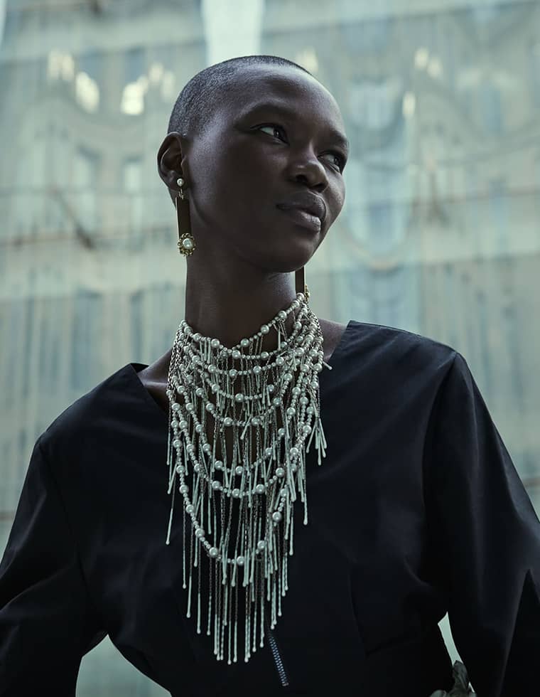 Collier de perles multi-rangs et boucles d’oreilles Delphine-Charlotte Parmentier portés par un mannequin.