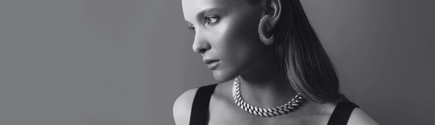 Lucie Domenach de profil en noir et blanc portant le collier Nebula et les boucles d’oreilles Spirale DCP.