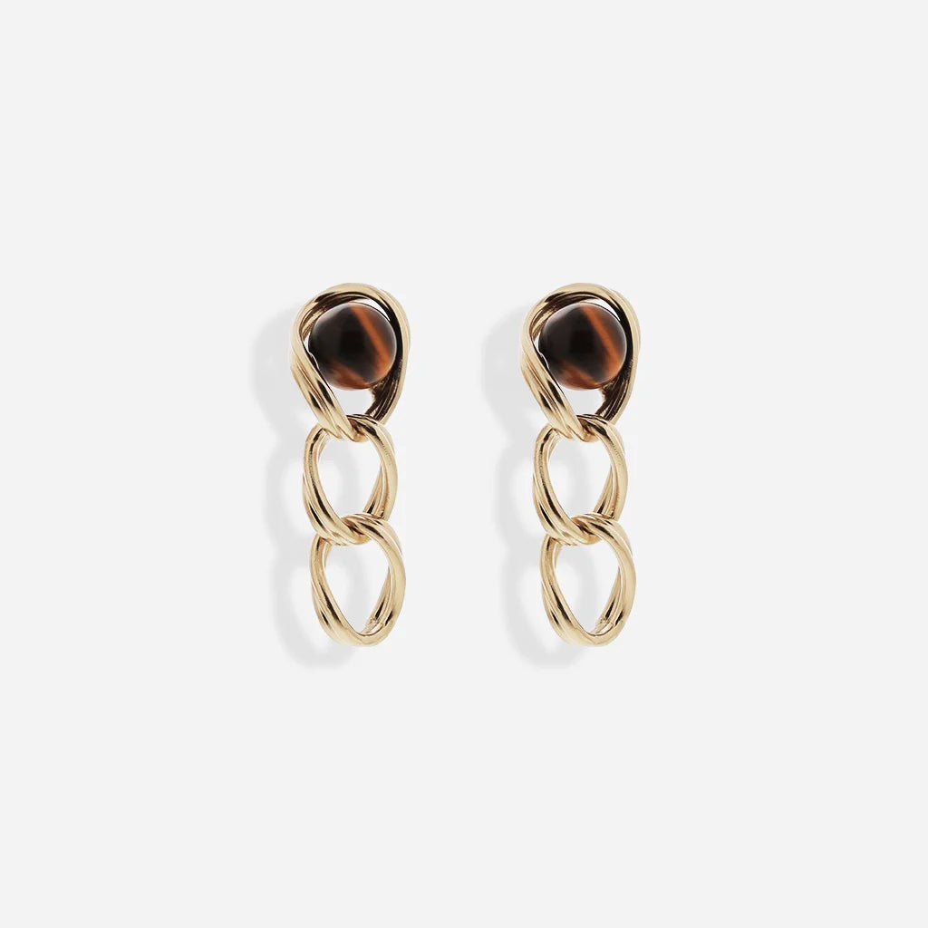 Boucles d’oreilles perles pendantes Anomalie avec trois anneaux torsadés en métal satiné doré et œil de tigre.