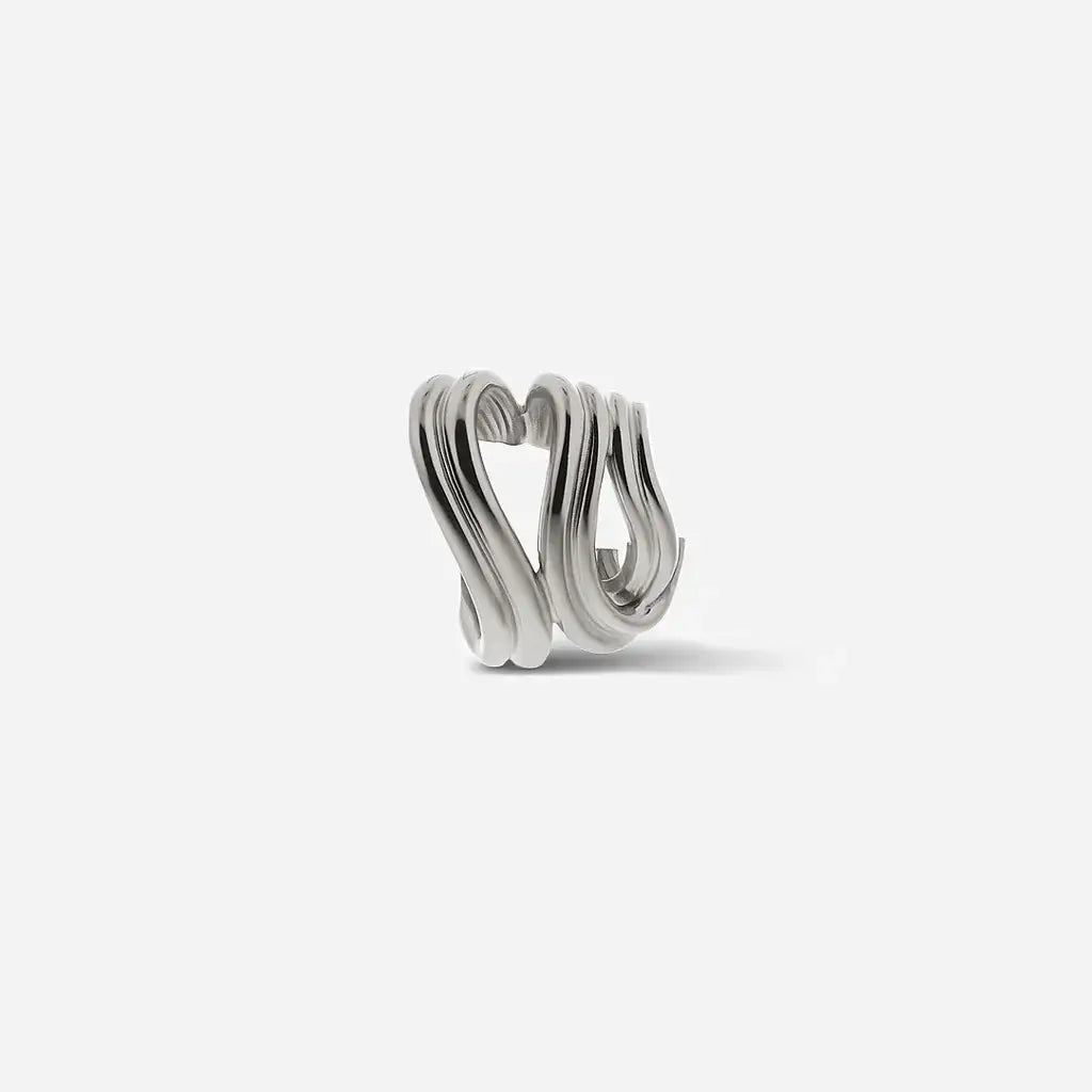 Une manchette d'oreille Anomalie sculpturale et graphique en métal satiné argenté avec une forme ouverte.