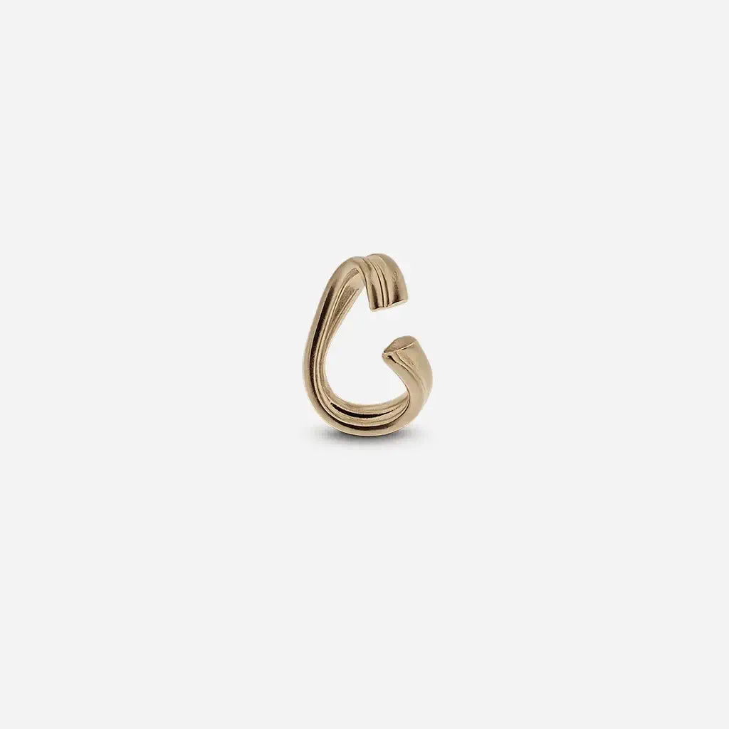 Bijou d'oreille en métal satin doré sculptural et minimaliste, graphique avec ses lignes douces.
