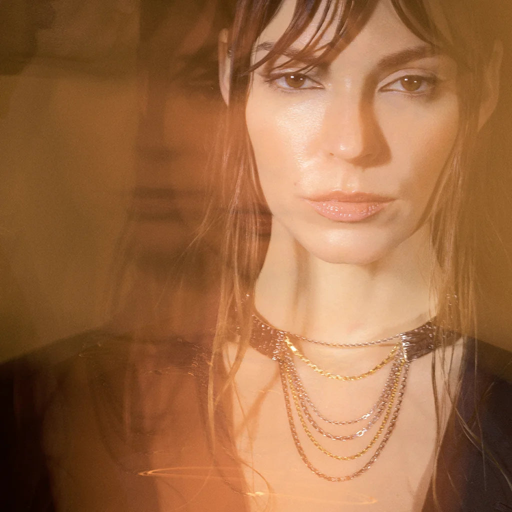 Une femme portant un collier multi rangs Trouble avec design bicolore en vieil argenté et doré à plusieurs rangs.