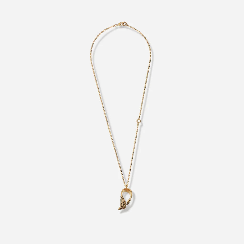 Un collier pendentif ailes Trouble en vieux doré orné de strass noirs, avec chaîne fine en métal et pendentif en aile.