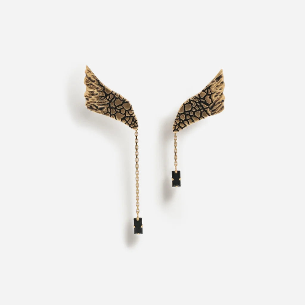 Boucles d’oreilles ailes Trouble en vieux doré, à forme asymétrique avec finition gravée et texture raffinée.