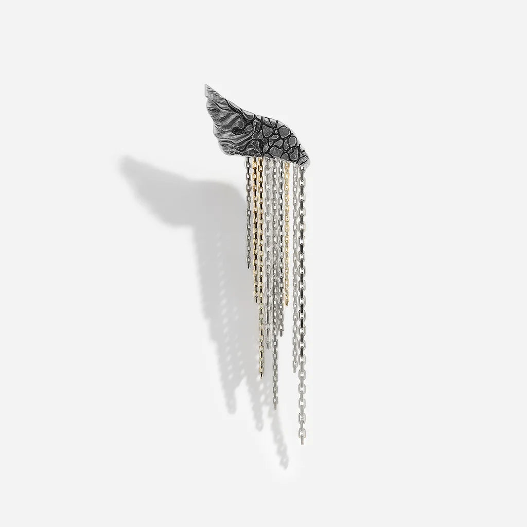 Une boucle d'oreille originale créateur Trouble en vieil argenté et mélange de chaines dorées et argentées.