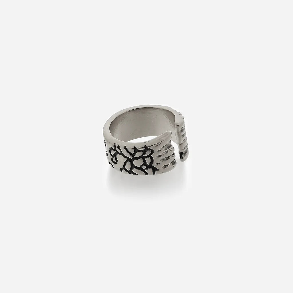 Bague texturée Trouble en métal vieil argenté, ouverte et structurée, avec motif craquelé rappelant une matière fissurée.