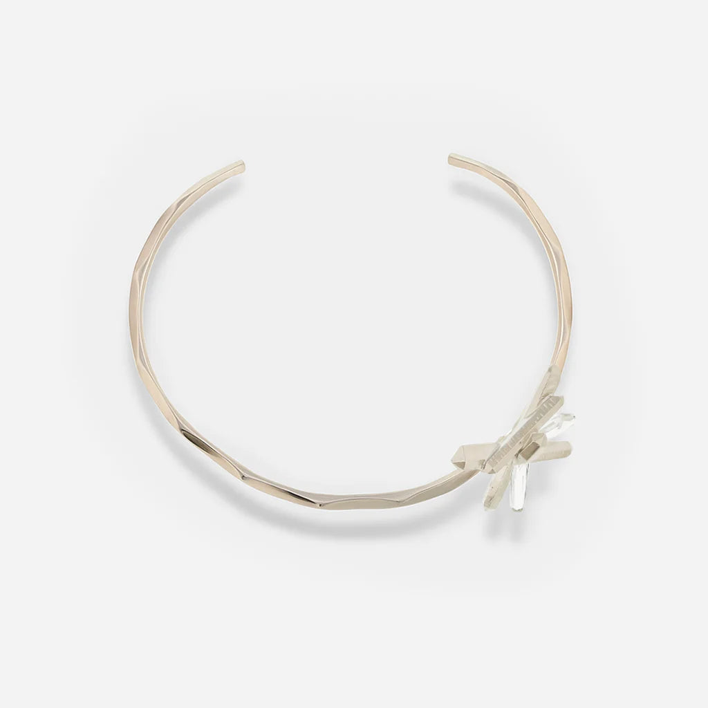 Collier torque rigide Turbulence en métal satiné doré avec motif en cristal de roche. 