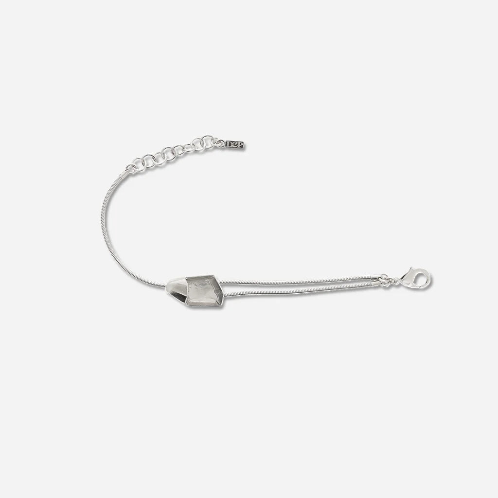 Bracelet cristal de roche Turbulence aux lignes asymétriques, monté sur une double chaîne fine en métal argenté.