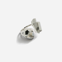 La bague cristaux de roche Turbulence en métal argenté rehaussée de deux cristaux aux formes irrégulières.