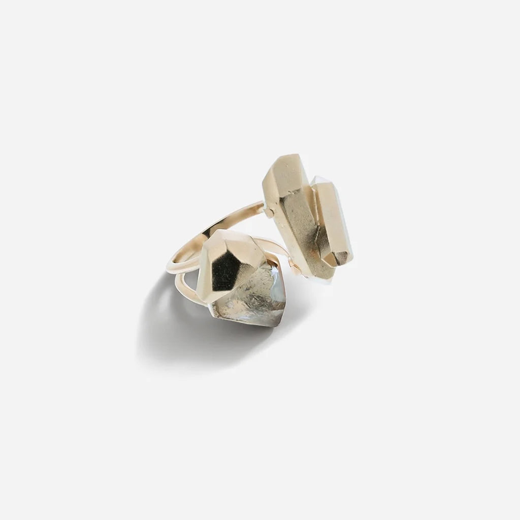 Bague cristaux de roche Turbulence avec design sculptural asymétrique en métal doré et cristaux aux formes irrégulières.