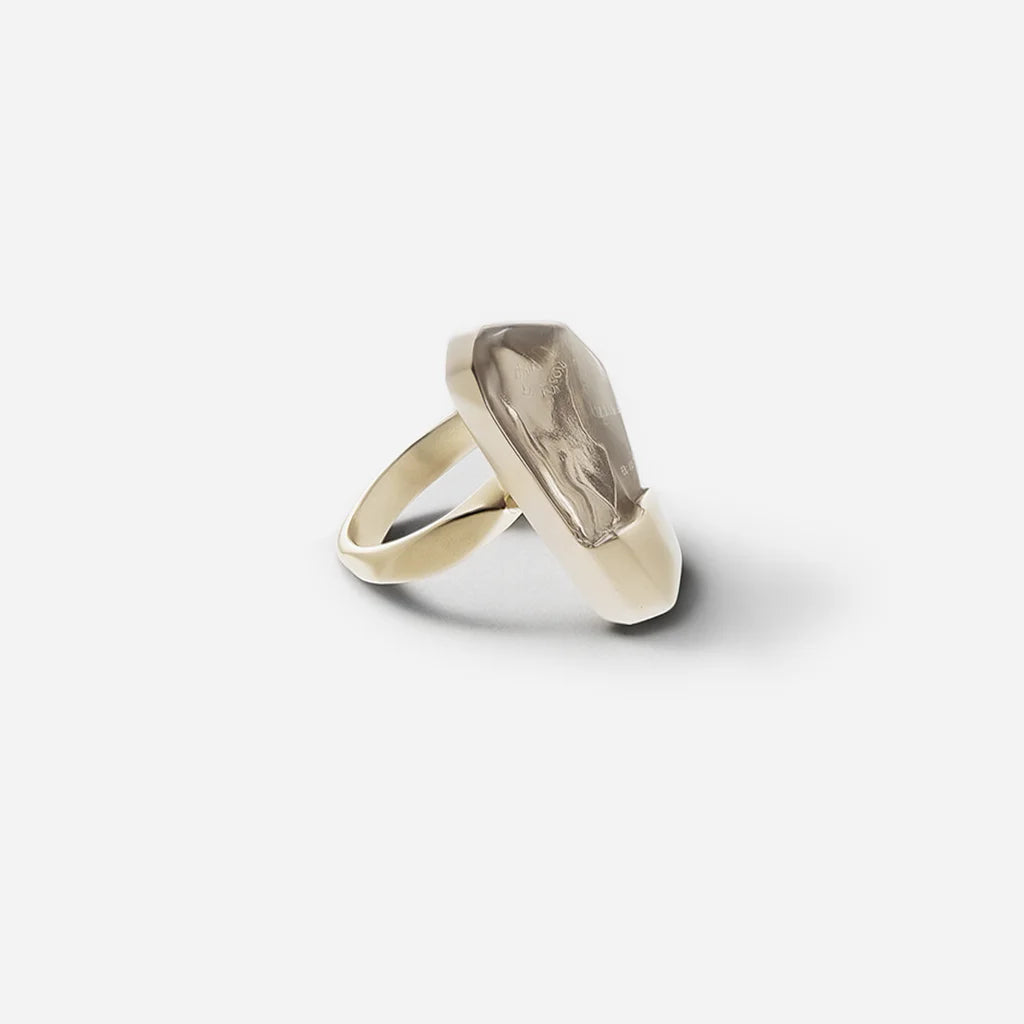 La bague cristal de roche Turbulence en métal doré mise sur une géométrie brute et un éclat minéral.