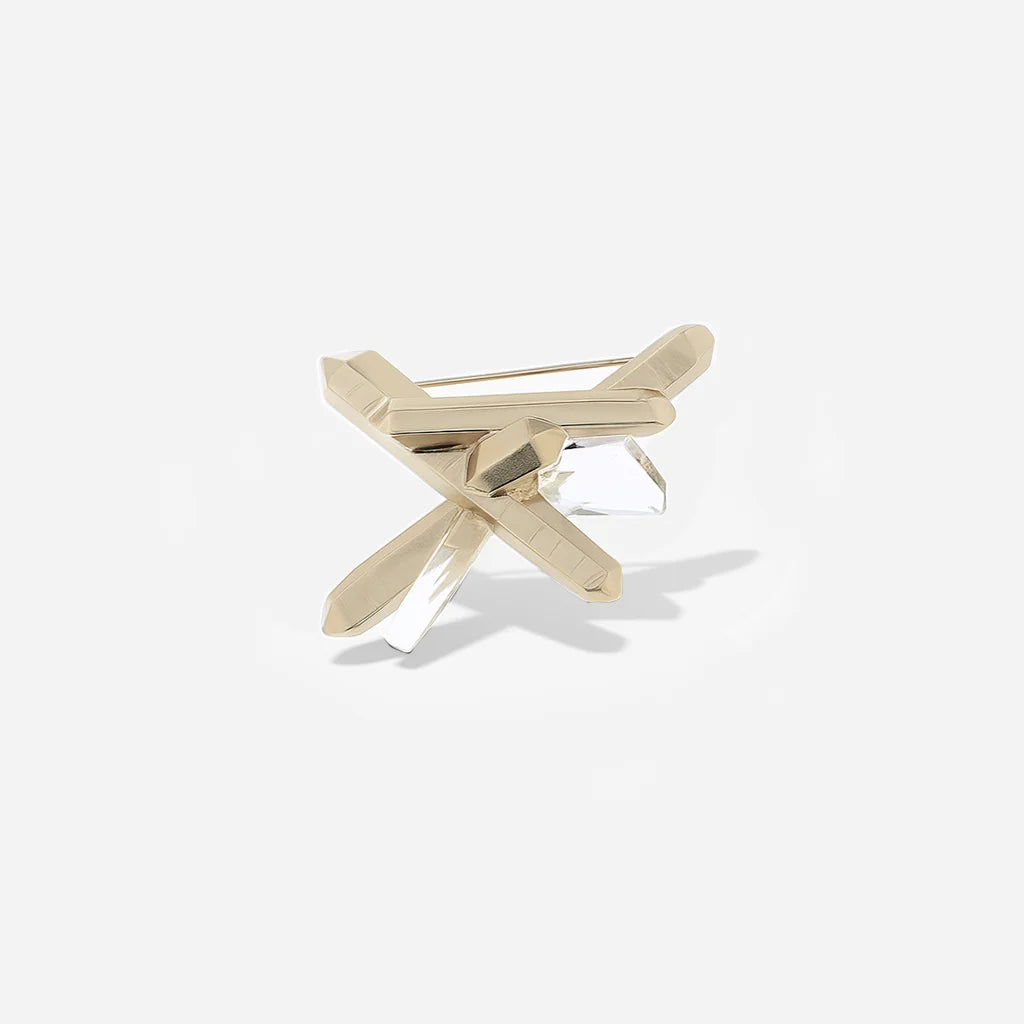 La broche cristal de roche Turbulence en métal doré présente une forme asymétrique.
