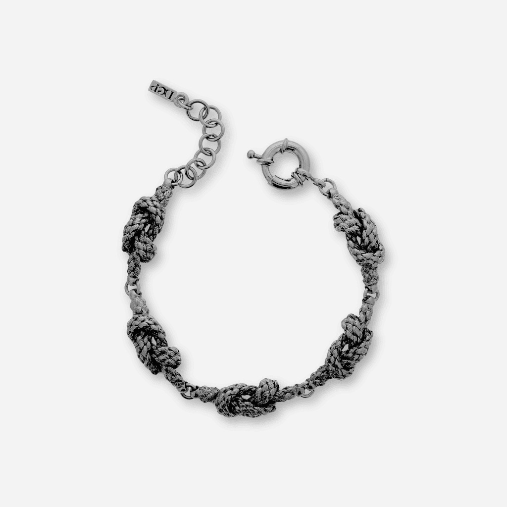 Bracelet en métal vieil argenté texturé, motif tressé avec nœuds sculptés, fermoir ressort et chaînette de réglage