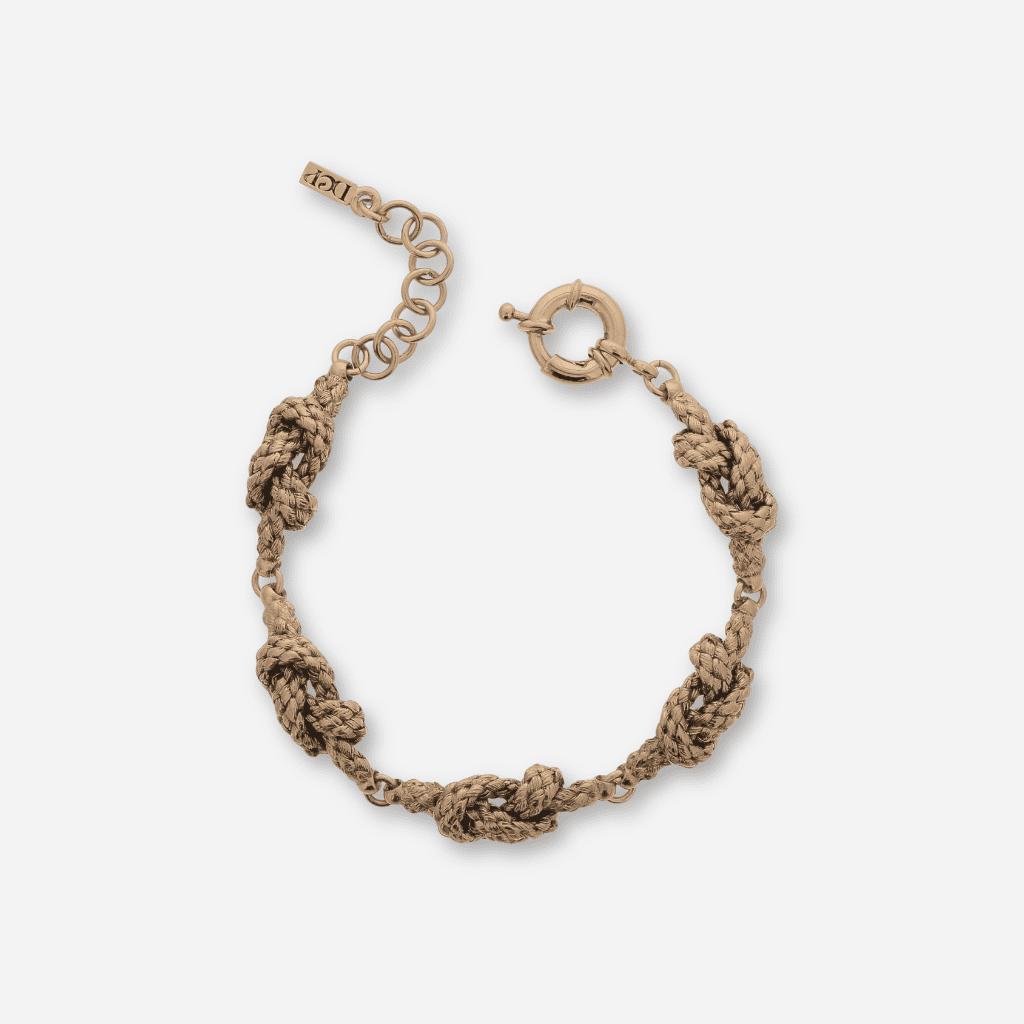 Bracelet en métal vieux doré texturé, motif tressé avec nœuds sculptés, fermoir ressort et chaînette de réglage
