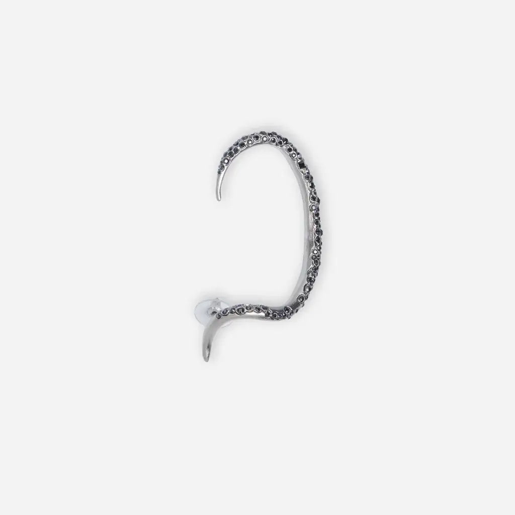 Boucle d’oreille Serpent N26 en métal satiné argenté, ornée de strass noirs, enroulée autour de l’oreille, graphique.