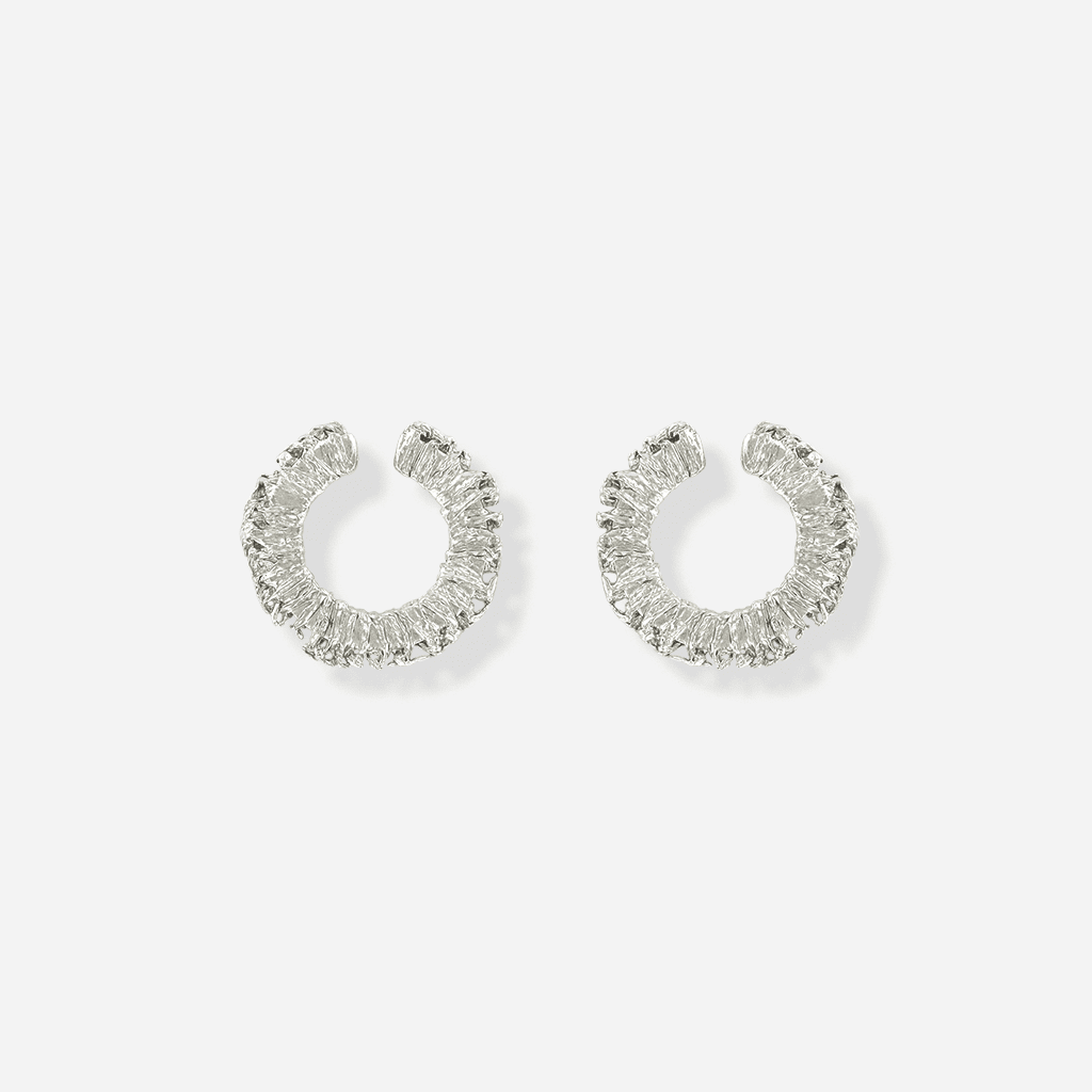 Petites boucles Spirale en métal argenté, anneaux texturés et sculpturales s’insérant dans le creux de l’oreille.