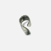 La bague Spirale, sculpturale et rigide en métal satiné ruthénium, s’enroule autour du doigt pour un confort optimal.