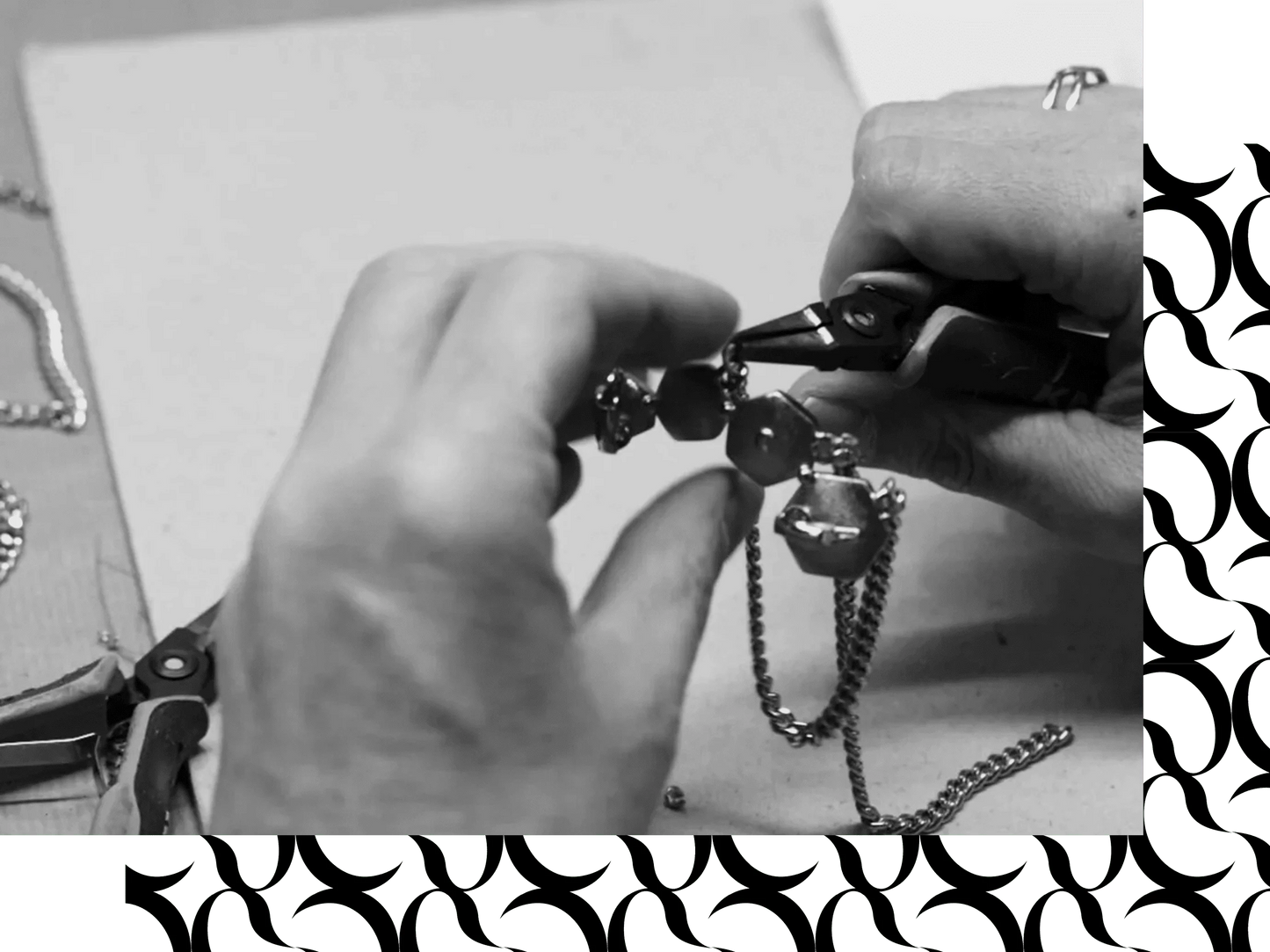 Photo en noir et blanc d’un travail de fabrication artisanale de bijou avec chaîne métallique et pince de précision.