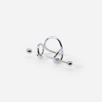 Une bague bicolore avec fibule Balem graphique, en métal argenté et doré brillant.