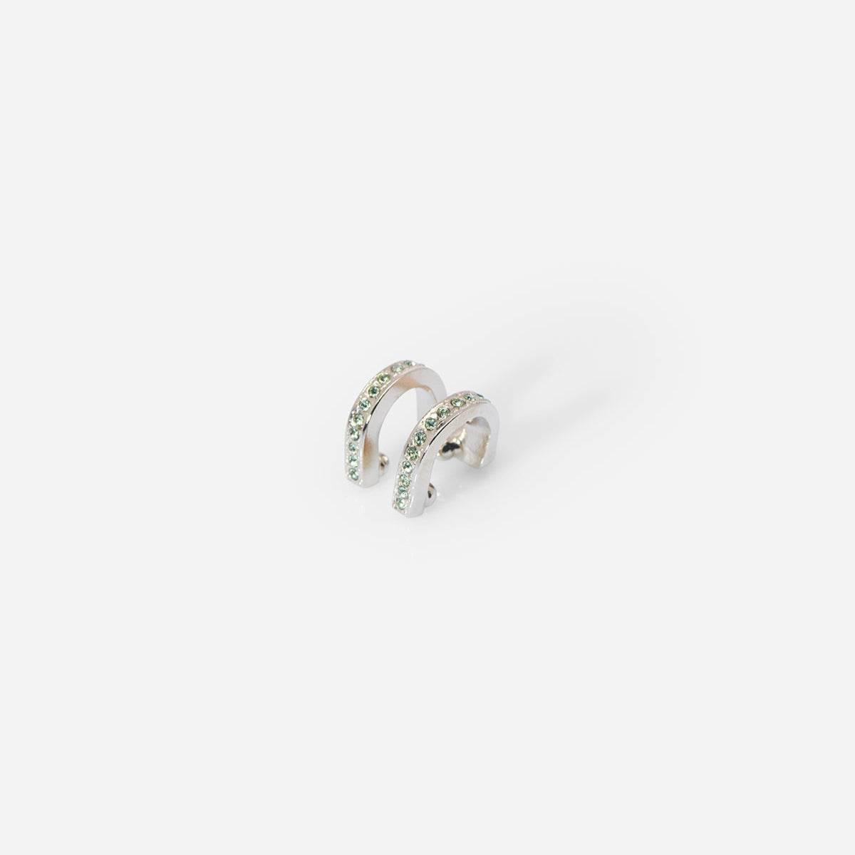 Bijou d’oreille Eden en métal satiné doré, double barrette arrondie ornée de strass verts, au design graphique.