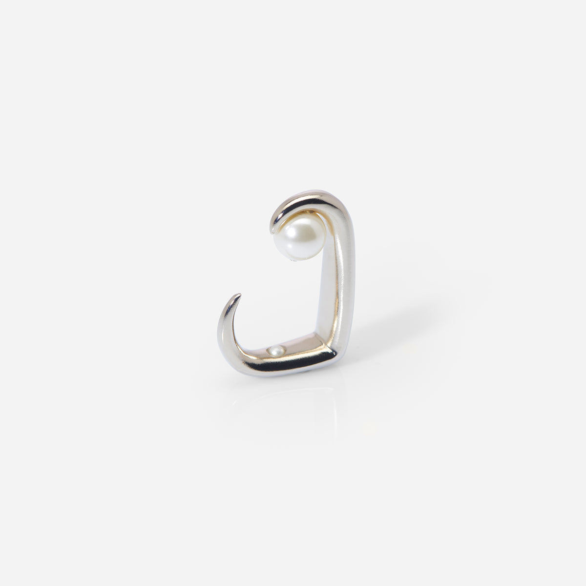 La bague Noé au design architectural ouvert, en métal doré et crème, ornée d’une perle laquée suspendue.