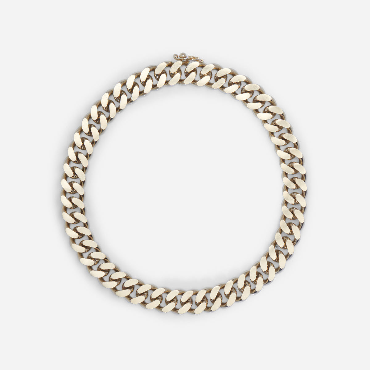 Collier chaîne gourmette Nebula avec large maille en métal satiné doré, design graphique.